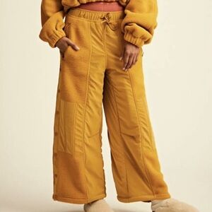 FREE PEOPLE MOVEMENT Game Time Fleece wide leg pants in mustard yellow.